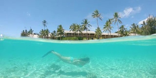 慢动作:年轻女子度假时在完美的热带水域浮潜。