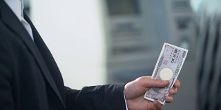 男子准备兑换日元在银行分行，工资在外币