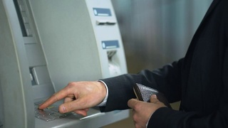 商人将信用卡插入ATM机，输入密码收钱视频素材模板下载