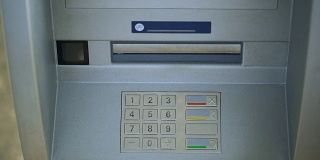 男人在ATM键盘上输入密码，银行交易俯视图，钱