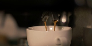 餐厅的咖啡机正在准备新鲜的咖啡并将其倒入白色的杯子中