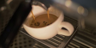 咖啡从咖啡机倒入杯子在餐厅关闭