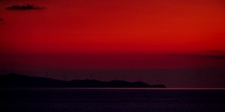 日落时风力涡轮机农场的海景