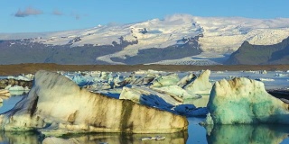 4k时间移动的云与蓝色冰山漂浮在Jokulsarlon冰湖，冰岛