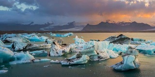 日落时分，冰岛东南部Vatnajkull国家公园附近Jökulsárlón冰川泻湖水域中的冰川。缩小。4 k UHD间隔拍摄。