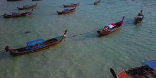 鸟瞰图跟踪长尾船和岩石海岸与水晶清澈的绿松石水Koh Lipe, Satun，泰国