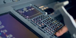 一个飞行员在仪表盘上转盘，特写。