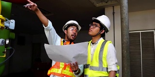 慢镜头:两名亚洲工程师正在检查工厂的电气系统