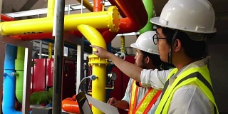 慢镜头:两名亚洲男性工程师正在检查工厂的气体系统