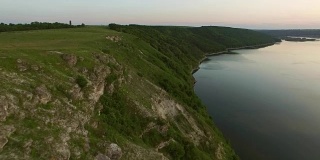 威严的无人机飞行通过乌克兰风景河Dnister。陡峭的岸边有石头。自然没有人。日落。FullHD