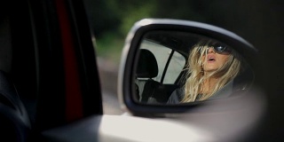 年轻女子看着汽车后视镜