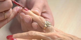 指甲专家正在涂红色指甲油。