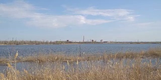 废弃的化工厂，河岸上有烟囱
