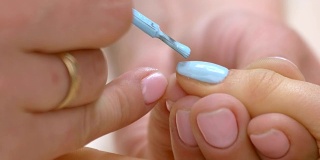 在女性指甲上涂指甲油的过程。