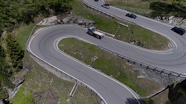 鸟瞰图山上蜿蜒的道路与卡车和汽车行驶在曲折起伏的欧洲瑞士4K