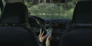 女司机在车里用智能手机
