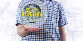 一个年轻人展示了地球的全息图和文字“比利时制造”