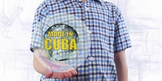 一个年轻人展示了地球的全息图，上面写着“古巴制造”