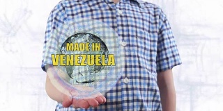 一个年轻人展示了地球的全息图，上面写着“委内瑞拉制造”