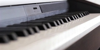 钢琴键盘微距视频拍摄。近距离观察钢琴琴键。近距离观察钢琴的琴键。白色和黑色的琴键。
