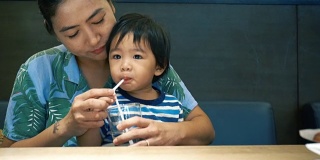 亚洲男婴和妈妈一起喝水
