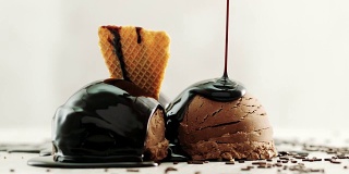 巧克力冰淇淋，旁边放巧克力片，淋上巧克力酱