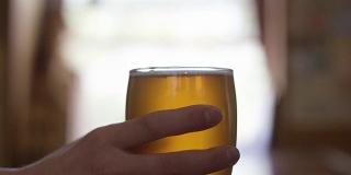 一个酒吧吧台对面的酒保把啤酒递给别人的特写镜头