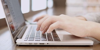 年轻商人的双手在工作空间用笔记本电脑打字。自由职业生活方式或教育研究概念。