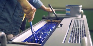 男工人甚至用刷子在机器的一个特殊部位刷上一层蓝色油漆。4 k。