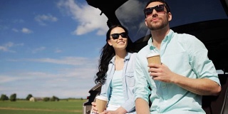 一对幸福的夫妇在车后车厢喝咖啡