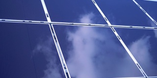 天空反射在一个矩形太阳能组件的表面上。太阳能电池板的农场。