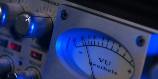 老卷轴磁带录音机关闭。标准体积指示器刻度的浅自由度。老式音频设备模拟VU仪表。录音室。蓝色霓虹灯