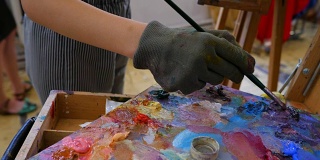 油画颜料的木制艺术调色板。混合颜色。色彩丰富的艺术乐器。工作工具与挤出管油漆