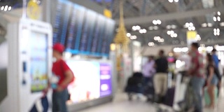 模糊的画面显示，乘客们看着机场的起落板，走进国际机场的候机楼。带有散焦效果的4K视频。