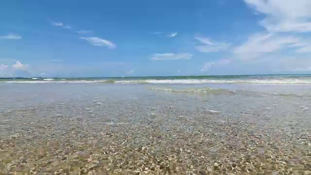阳光明媚的泰国热带海景海滩，海浪拍打着沙滩，低角度视角，4K Dci分辨率