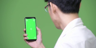 年轻的亚洲商人在展示拷贝空间时使用手机