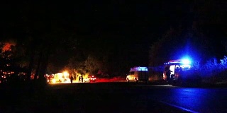 夜间事故现场，急救车辆和救护车在背景中
