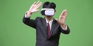 年轻的亚洲商人使用虚拟现实头盔