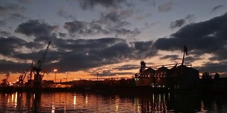 傍晚海港的大型粮食码头全景。谷物散货在夜间转船。从泊位的大型电梯装载粮食作物上船。农产品运输