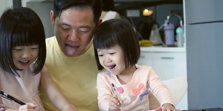中年亚洲爸爸花时间陪他可爱的小女儿