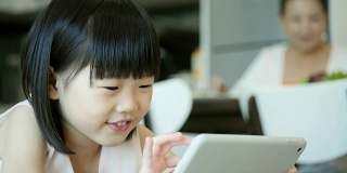 可爱的小女孩在数字平板电脑上玩游戏