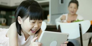小女孩在平板电脑上看动画片