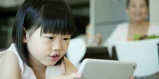 小女孩在平板电脑上玩电子游戏