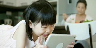 快乐的小女孩在平板电脑上看东西