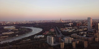 俄罗斯日落天空莫斯科城市景观河流和大学交通街道空中全景4k