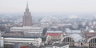 里加,拉脱维亚。顶视图城市景观在薄雾雨天。拉脱维亚科学院、里加国际长途汽车站和里加中央市场