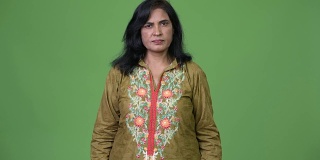 成熟美丽的印度妇女穿着传统服装在绿色的背景