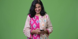 成熟快乐美丽的印度女人微笑着使用电话