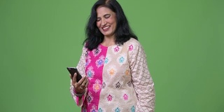 成熟快乐美丽的印度女人微笑着使用电话