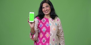 成熟快乐美丽的印度女人微笑着展示手机